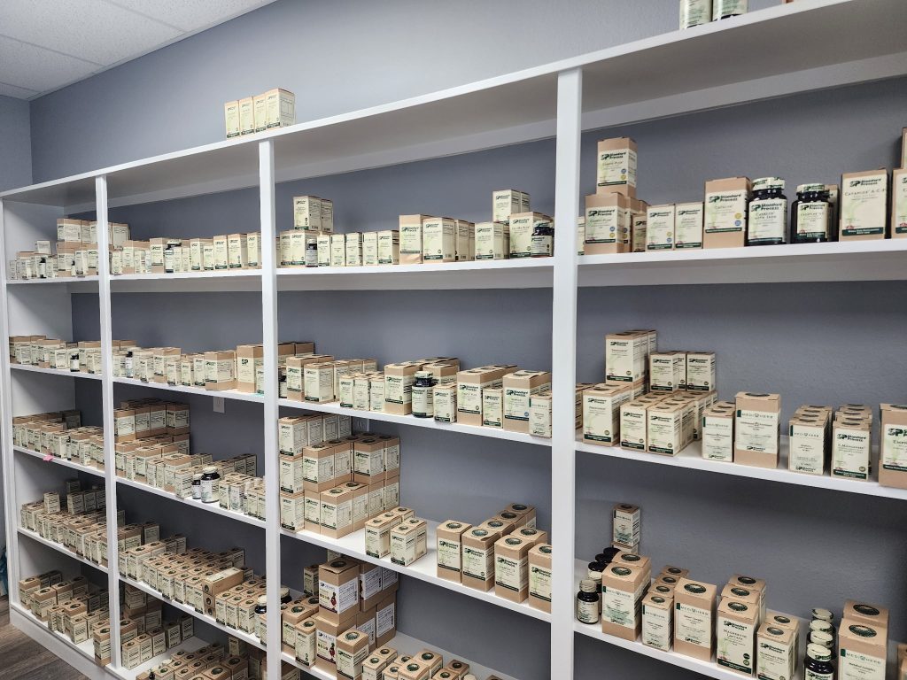 A long wall of white shelves stocked with whole-food supplements inside Nutrition Source
